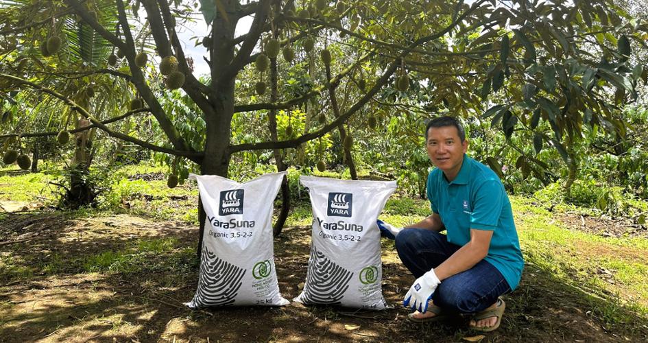 Durian farmer in Vietnam, holding Yara Suna bags